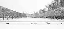 Photo en noir et blanc d'un parc et d'un château sous la neige