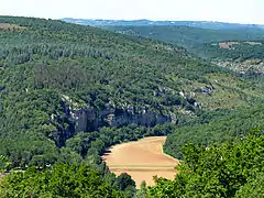 Paysage des Causses du Quercy : collines recouvertes de pelouse calcaire et de forêt méditerranéenne, terres agricoles en vallée.