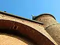 Photographie d'un trou sous l'arcade d'une fortification en briques rouges