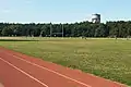 Vue sur la piste d'athlétisme, la colline de Parilly et son château d'eau