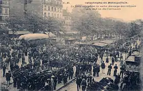 Carte postale en noir et blanc montrant une foule à la sortie d'une station de métro