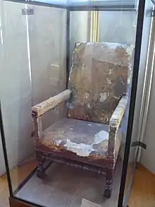 Photo récente du fauteuil dans une vitrine de musée.