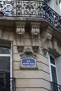 No 15 : plaque de rue et détail du balcon filant.