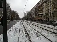 Le boulevard Brune en 2010, sous la neige, avec un tramway de la ligne T3, selon sa dénomination d'alors, circulant sur une plateforme réservée à son usage.