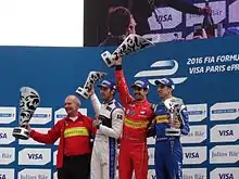Photo de quatre hommes portant des trophées