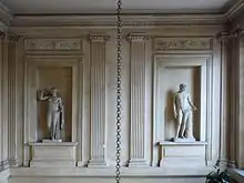 Vue frontale des statues d'Aphrodite et d'Apollon dans le vestibule de l'hôtel du Châtelet.