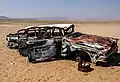 Carcasse de voiture dans le désert du Parc national d'Iona; les pannes sèches sont à éviter absolument dans cet environnement.