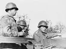 Photographie de trois soldats dans une jeep