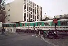 Photographie d'une rame circulant en ville au niveau d'un passage à niveau