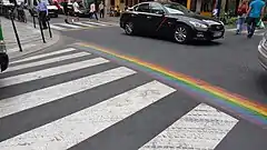 Passage piéton aux couleurs du drapeau arc-en-ciel dans le quartier du Marais en 2018, situé sur le carrefour de la place Harvey Milk.