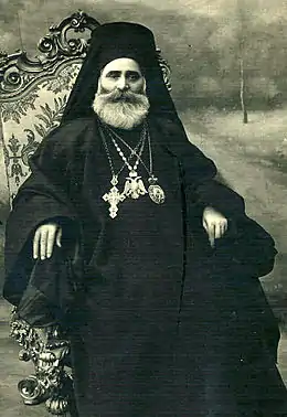 Photographie d'un pope orthodoxe assis.