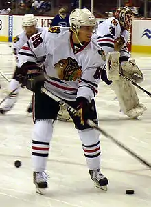 Photographie d'un joueur de hockey sur glace avec un maillot et un casque blanc