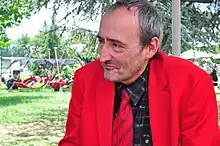 Portrait photo de Patrick Roy en veste rouge vif.