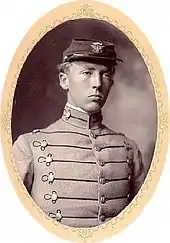 Photographie dans un cadre ovale avec un jeune homme portant un calot et une veste d'uniforme avec des brandebourgs