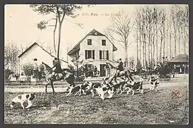 Photographie en noir et blanc de cavaliers sur leur chevaux et de chiens de chasse.