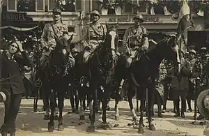 Photographie en noir et blanc de personnages montant des chevaux.