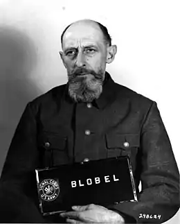 Paul Blobel (1884-1951), commandant du sonderkommando 4a de l'einsatzgruppe C, a organisé et exécuté le grand massacre de Babi Yar, en 1941, a été le premier à utiliser un camion à gaz, a développé les chambres à gaz pour les camps d'extermination en Pologne, a dirigé en 1942 l'opération 1005 pour exhumer des millions de corps sur les sites de massacre en 'Europe de l'Est dans le but d'effacer toutes les preuves de la Shoah.