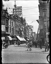 Entrée de la rue en 1934. On aperçoit l'enseigne du Cinéac et une publicité pour les cigarettes Kyriazi Freres (en). Photo de Paul Guermonprez.