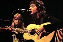 Le couple McCartney sur scène, Paul chantant et jouant de la guitare, Linda en arrière plan