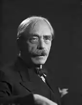 Portrait photographique en noir et blanc d'un homme grisonnant, au regard clair, portant une moustache, vu de trois-quarts droit