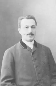 Photographie en noir et blanc d'un homme à moustache.