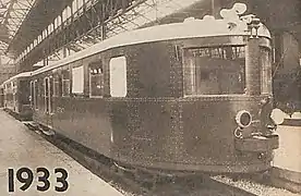 Photographie en sépia montrant une vue de trois quart avant d'une Pauline, caisse foncée et toit blanc.