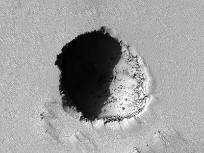 Lucarne de 180 m sur le flanc sud du volcan par le HiRISE.