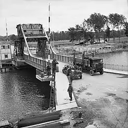 Photo noir et blanc d'un camion passant sur un pont.