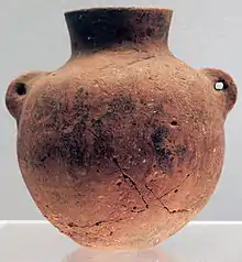 Terre cuite rouge à pâte fine, lissée. Culture de Peiligang, VIe millénaire av. J.-C.. Bouteille de type hu, à deux oreilles verticales perforées pour la corde. H. 11,2 cm.Musée de Shanghai.