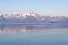 Une vaste étendue d'eau avec au fond de hautes montagnes enneigées.