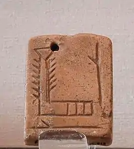 Petite tablette en argile comprenant deux signes proto-cunéiformes.
