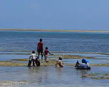 Groupe de Kényans prenant un bain de mer à marée basse à Nyali Beach.