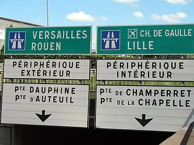 photo de panneaux de signalisation : Lille et périph intérieur à droite, Rouen et périph extérieur à gauche