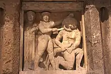 Persée au centre tient Méduse, à droite, dans les mains. Persée n'a pas de bouclier et utilise une épée. Athéna est à gauche.