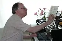 photo d'un homme au piano, annotant une partition