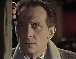 Peter Cushing en Van Helsing. Ce dernier semble effrayé ou surpris et a un regard fixe.