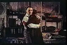 Une scène des Maîtresses de Dracula avec Peter Cushing : il serre dans ses bras une femme éplorée.