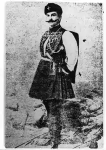 Photographie en noir et blanc montrant un homme moustachu portant la fustanelle.