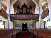 Église protestante. Vue intérieure de la nef vers la tribune d'orgue.