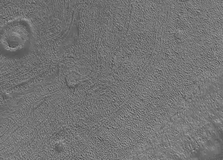 Gros plan sur la surface de Phaethontis. Les cavités visibles pourraient avoir été formées par la sublimation de glace d'eau.