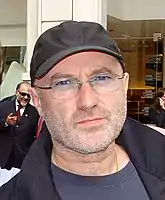 Photographie d'un homme portant une casquette noire et des lunettes.