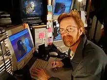 Le réalisateur Phil Nibbelink, travaillant à l'élaboration de son film, devant quatre écrans, et dessinant un croquis.