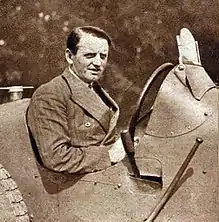 Photo d'un homme prenant la pose au volant de son véhicule.