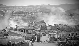 Des habitations en ruine, avec la fumée qui en sort.