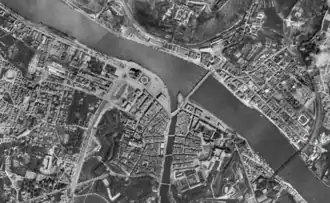 Photographie aérienne de la ville, montrant deux cours d'eau se rejoignant et les bâtiments.