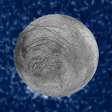 Des tâches blanches sont visibles au sud de la lune. Le ciel est constellé d'étoiles derrière.