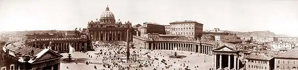 Photo panoramique de la place Saint-Pierre, avec en son centre l'obélisque, et la basilique en arrière plan