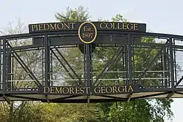 Un pont pédestre fer sur lequel est inscrit « Piedmont College, Demorest, Georgia ».