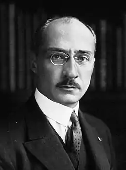 Photographie en noir et blanc du visage d'un homme portant luenettes et moustaches