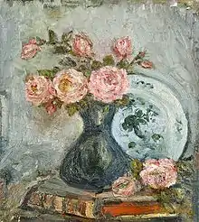Tableau d'un vase bleu avec des fleurs roses, posé sur un livre avec reliure ancienne, sur une table, devant une assette adossée au mur